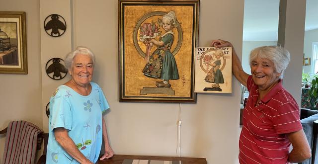 Anne Dyer, RSCJ (left), and Bee Dyer Gonnella(right) pose with an original 1926 Leyendecker Saturday Evening Post illustration