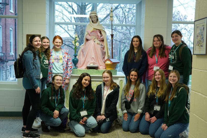 Students pose with the statue of Mater located at the Academy of the Sacred Heart in St. Charles